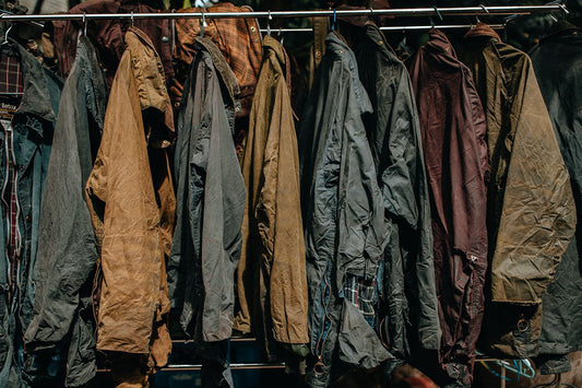 Rail of faded vintage Barbour waxed jackets with worn, dry wax that needs reproofing